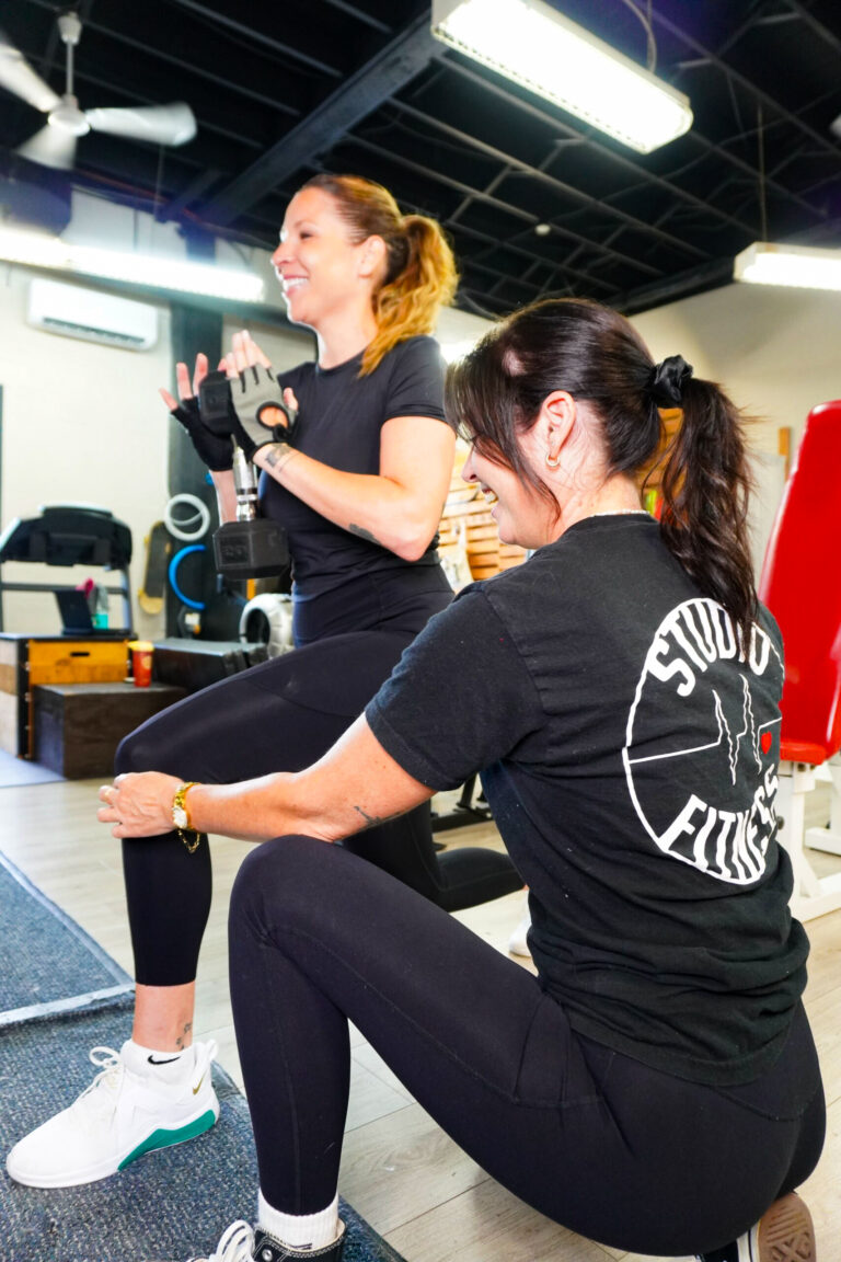 Coach Sophie guide une cliente lors d’un entraînement personnalisé au gym.